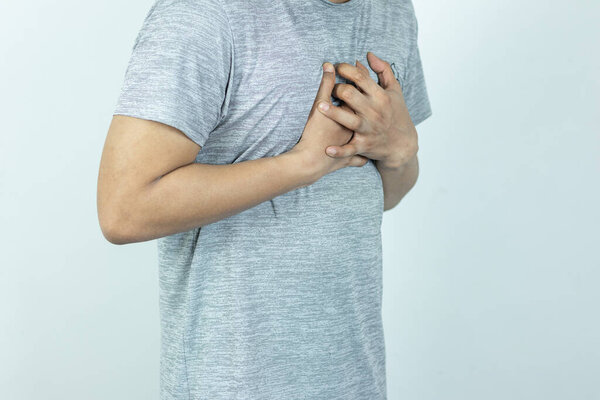 asian man pressing chest with painful expression. Severe heartache, having a heart attack or painful cramps, heart disease.