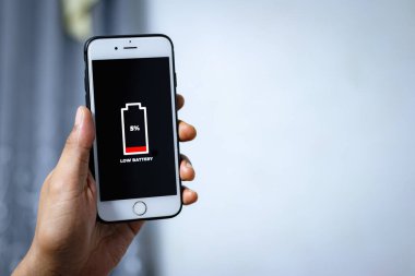 Hücresel Sorunlar ve Enerji Konseptleri. Erkek, elinde akıllı bir telefon ve ekranda düşük pil simgesi var..