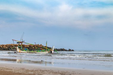 Endonezya 'nın Madura Adası, Sumenep kıyılarında yüzen geleneksel balıkçı tekneleriyle berrak bir gökyüzü manzarası.