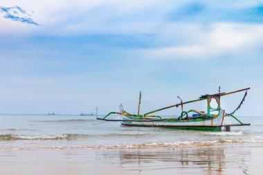Endonezya 'nın Madura Adası, Sumenep kıyılarında yüzen geleneksel balıkçı tekneleriyle berrak bir gökyüzü manzarası.