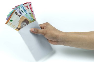 Asyalı bir adamın elinde Rupiah Yığını ya da IDR banknotlarını beyaz arka planda beyaz zarfın içinde tutuyor.