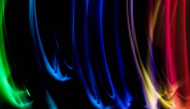 Siyah arkaplan ve duvar dokusunda soyut renkli düzensiz çizgiler. Uzun pozlama. Hafif resim fotoğrafçılığı.