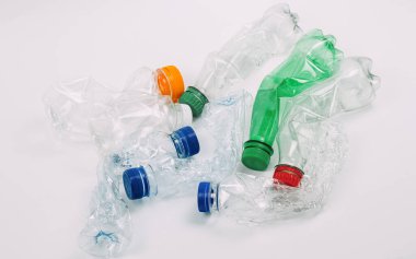 Beyaz arka planda ezilmiş plastik şişe yığını.