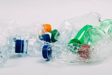 Beyaz arka planda ezilmiş plastik şişe yığını.