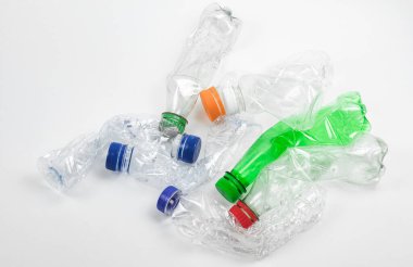 Beyaz arka planda ezilmiş plastik şişe yığını.