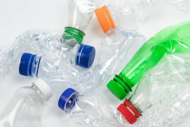 Beyaz arka planda ezilmiş plastik şişe yığını.