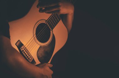 Adam akustik gitara sarılıyor. Müzik arkaplanı