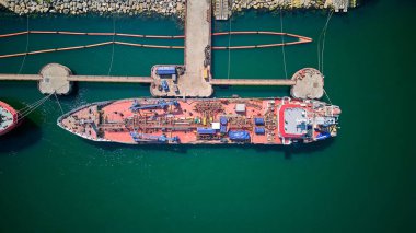 Petrol terminali, limandaki petrol tankeri gemisinin hava görüntüsü, petrol ve petrokimyasal ürünlerin daha sonraki depolama tesislerine taşınması için hazırlanmış endüstriyel bir tesistir. Ticari lojistik ve ulaşım ithalatı için hazır.