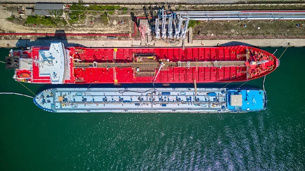 Petrol terminali, limandaki petrol tankeri gemisinin hava görüntüsü, petrol ve petrokimyasal ürünlerin daha sonraki depolama tesislerine taşınması için hazırlanmış endüstriyel bir tesistir. Ticari lojistik ve ulaşım ithalatı için hazır.