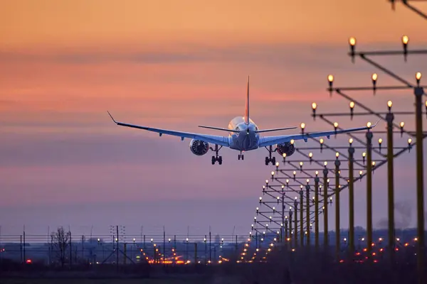 Samolot Pasażerski Ląduje Podczas Wspaniałego Zachodu Słońca Zdjęcie Stockowe