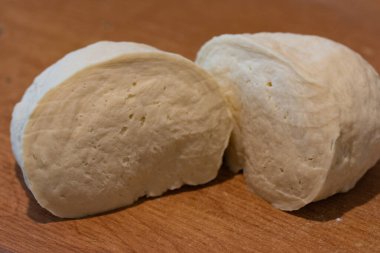 Ahşap bir masada hamuru kes, yemek yap.