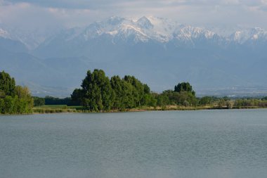 Göl karla kaplı dağların ardında.