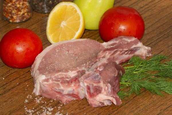 raw pork steak with vegetables and spices