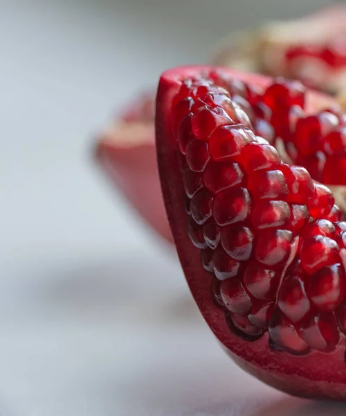 two halves of pomegranate, red grains close up