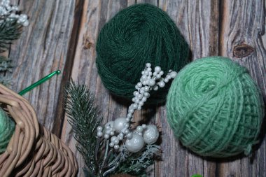 Ahşap işlemeli arka planda sepetteki yeşil iplik, tığ işi..