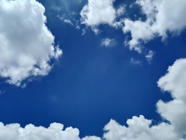 Parlak gökyüzündeki beyaz bulutlar duvar kağıdı veya arkaplan resmi olarak kullanılabilir.