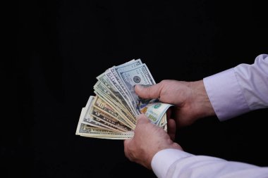 Erkek el para teklif ediyor, Amerikan doları banknotları, Amerikan doları kara arka plan, takas, ticaret ve para kazanma kavramı, finans ve iş dünyasına karşı