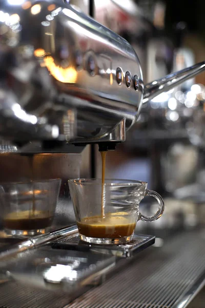 提供するためにコップを満たす専門のコーヒー メーカーから注ぐエスプレッソのコーヒー — ストック写真