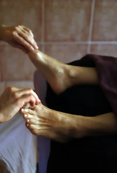 masseur giving reflexology foot massage