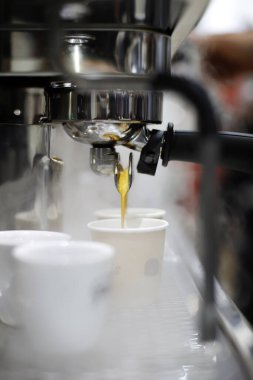 Espresso makinesi bir fincana kahve dolduruyor.