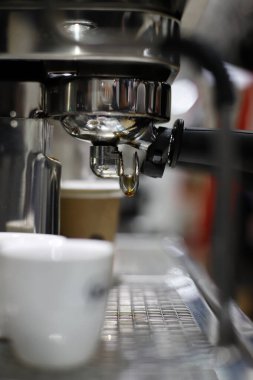 Espresso makinesi bir fincana kahve dolduruyor.