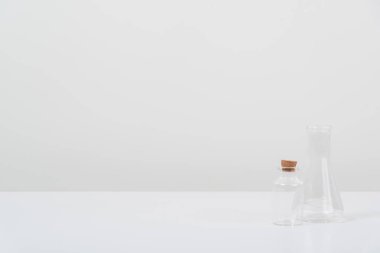 Beyaz arka plandaki beyaz masada bazı test tüpleri var.