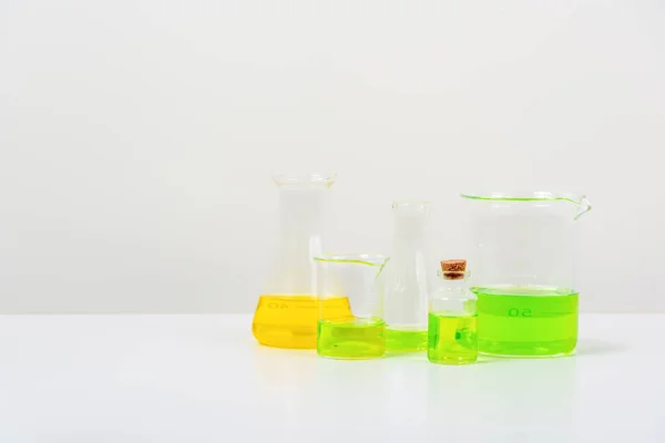Beyaz Masa Bilim Laboratuarında Deney Tüpleri Şişeler Renkli Sıvılarla Dolu — Stok fotoğraf