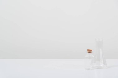 Beyaz arka plandaki beyaz masada bazı test tüpleri var.