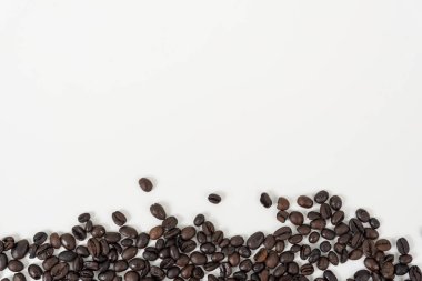 Beyaz masa arkaplanındaki kahve çekirdeklerinin üst görüntüsü,
