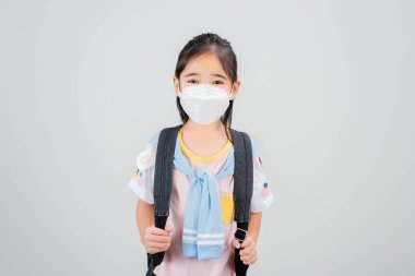 Asyalı küçük kız Coronavirus salgınını korumak için maske takıyor ve yeni virüs Covid-19 'u işaret ediyor. 