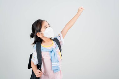 Asyalı küçük kız Coronavirus salgınını korumak için maske takıyor ve yeni virüs Covid-19 'u işaret ediyor. 