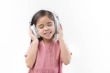 Küçük güzel bir kız Asia 'nın kulaklığı beyaz bir arka plana koyması..