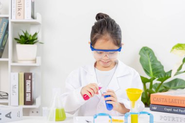 Kimya bilimi için mataraları olan mutlu bir Asya kızı beyaz bir arka planda izole edilmiş.