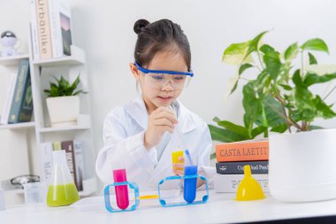 Kimya bilimi için mataraları olan mutlu bir Asya kızı beyaz bir arka planda izole edilmiş.