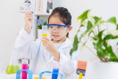 Kimya bilimi için mataraları olan mutlu bir Asya kızı beyaz bir arka planda izole edilmiş.