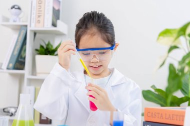 Kimya bilimi için mataraları olan mutlu bir Asya kızı beyaz bir arka planda izole edilmiş.