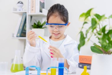 Kimya bilimi için mataraları olan mutlu bir Asya kızı beyaz bir arka planda izole edilmiş.