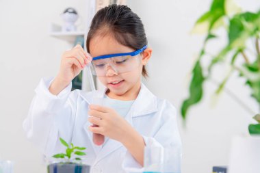 Kimya bilimi için mataraları olan mutlu bir Asya kızı beyaz bir arka planda izole edilmiş.