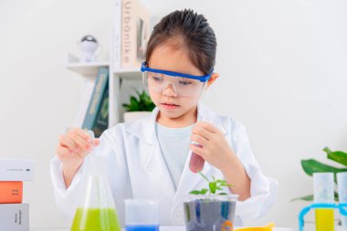 Kimya bilimi için mataraları olan mutlu bir Asya kızı beyaz bir arka planda izole edilmiş.