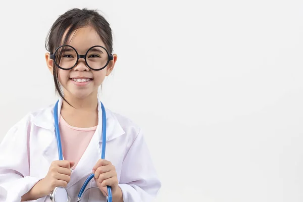 アジアの小さな女の子は白で孤立した医者を演じます — ストック写真
