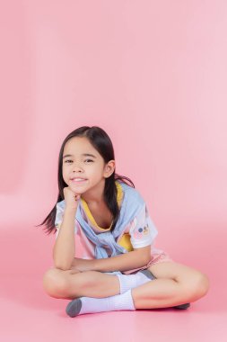 Pembe arka planda poz veren Asyalı çocuk resmi