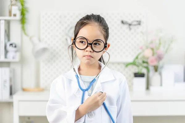 Kleines Mädchen Mit Weißem Arztkittel Und Stethoskop lizenzfreie Stockbilder