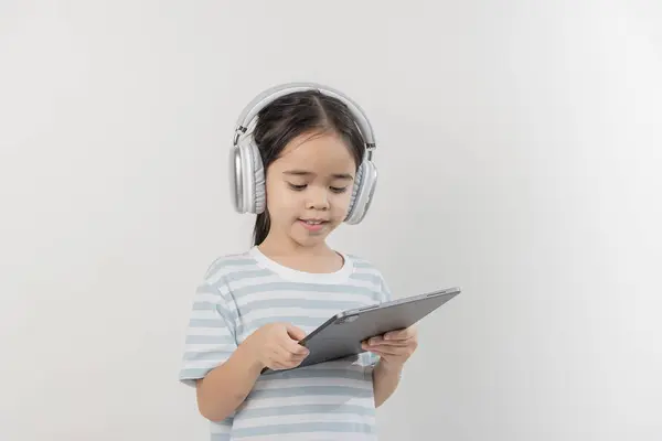 Lächelndes Kleines Mädchen Das Ein Tablet Mit Kopfhörer Der Hand — Stockfoto