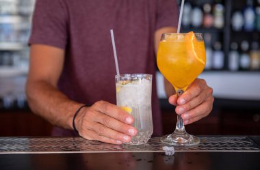 Barmen sıcak bir yaz gününde Kastos adası barında iki tane alkollü kokteyl hazırladı. Yatay olarak. Yakın plan..