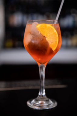 Tezgahın arkasında bir bardak Aperol spreyi kokteyli. Dikey. Yakın plan..