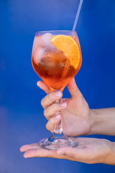 Bicchiere Aperol Spritz Cocktail Mani Femminili Fondo Blu Verticale Primo — Foto Stock