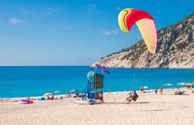 MYRTOS plajı, Yunanistan-20 Temmuz 2020: Eğitmen ve paraglider Yunanistan 'ın Kefalonia adasındaki Myrtos plajına indiler. Yatay.