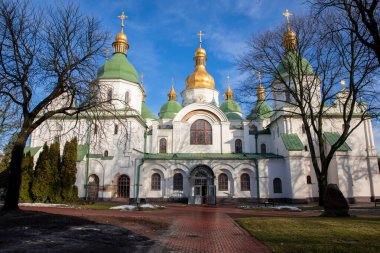 Kyiv Ukrayna 'daki Aziz Sophia Katedrali açık mavi gökyüzü altında güzel mimari öğeler ve altın kubbeler sergiliyor. Bu ortodoks katedrali tarihi bir simgedir ve her gün birçok ziyaretçi çeker..