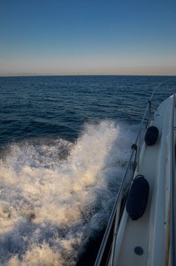 Yunanistan 'ın sakin sularında yüzen yelkenli, dalgalar ve sıçramalar yaratıyor, berrak gökyüzü altında güzel mavi deniz manzaraları sergiliyor, seyahat maceraları için ideal..