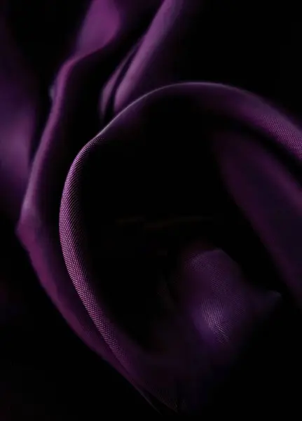 Close-up of crumpled vibrant purple textured fabric. Can be used as background for advertising jewelry, jewelry, luxury, graphic design.